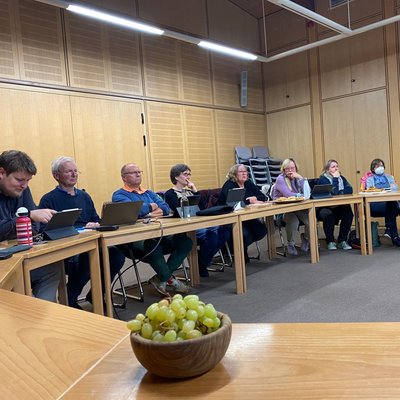 Foto aus dem Rathaus mit Tischen und 9 Mitgliedern der Grünen die das Wahlprogramm ausarbeiten. Einige haben Ihre Tablets oder Laptops auf dem Tisch stehen. Im Vordergrund steht eine Schale mit Weintrauben auf dem Tisch.