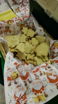 Auf dem Foto sind Plätzchen verschiedener Formen in einem Korb zu sehen. Zwischen den Plätzchen und dem Korb sind Servietten mit Weihnachtsmannmotiven.